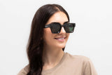 Woman wearing Noir Sunglasses, Oversized black square sunglasses with green polarized lens