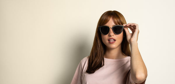 woman wearing Kraywoods heart face shape sunglasses collection on a pink background