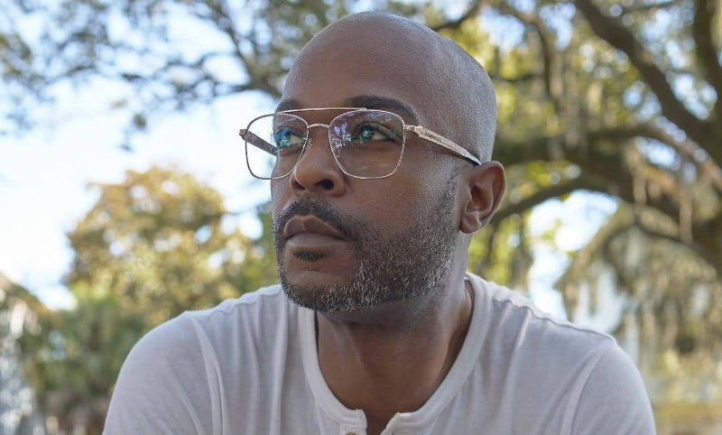 man outdoors wearing silver eyeglasses looking at the sky