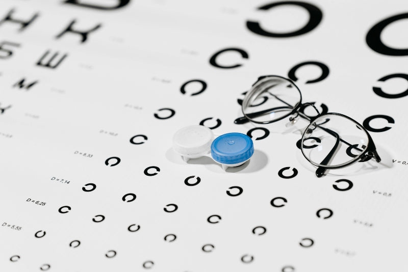 contacts and glasses on eye exam chart