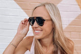 Femme portant des lunettes de soleil Runner, Green Tortoise Aviator