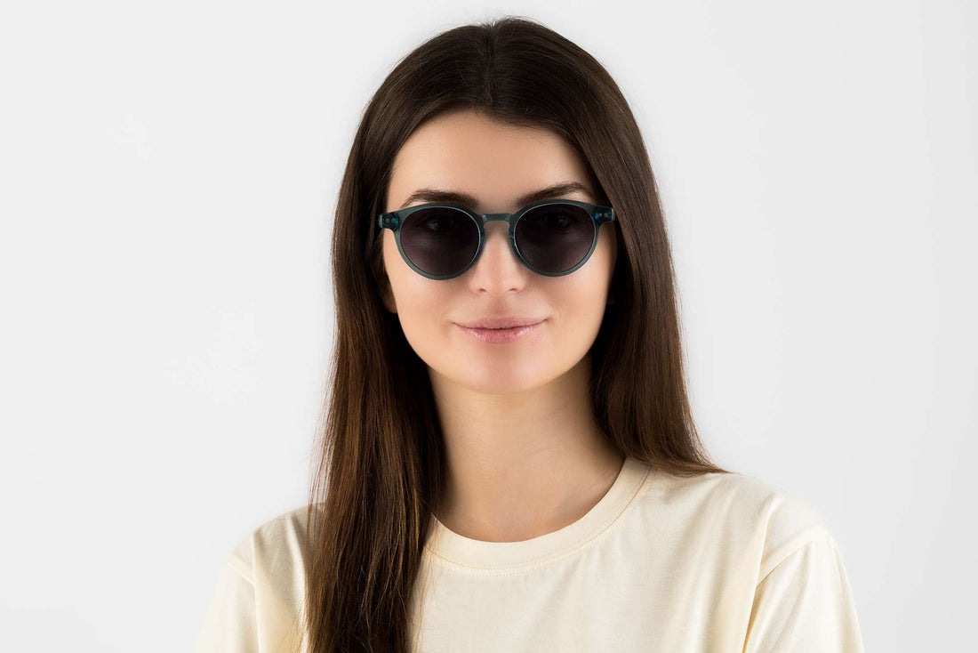 Femme portant des lunettes de soleil rondes, bleues et transparentes, de type Flash