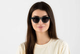 Femme portant des lunettes de soleil rondes, bleues et transparentes, de type Flash