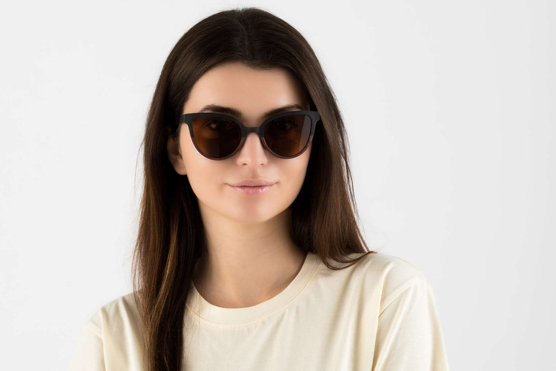 Femme portant des lunettes de soleil Ivy, en bois bicolore, de type œil de chat, avec verres polarisants