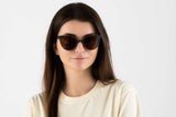 Femme portant des lunettes de soleil Ivy, en bois bicolore, de type œil de chat, avec verres polarisants