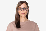 Femme portant des lunettes noires, rétro et rondes en bois de chêne.