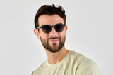 Femme portant des lunettes de soleil rondes, bleues et transparentes, de type Flash