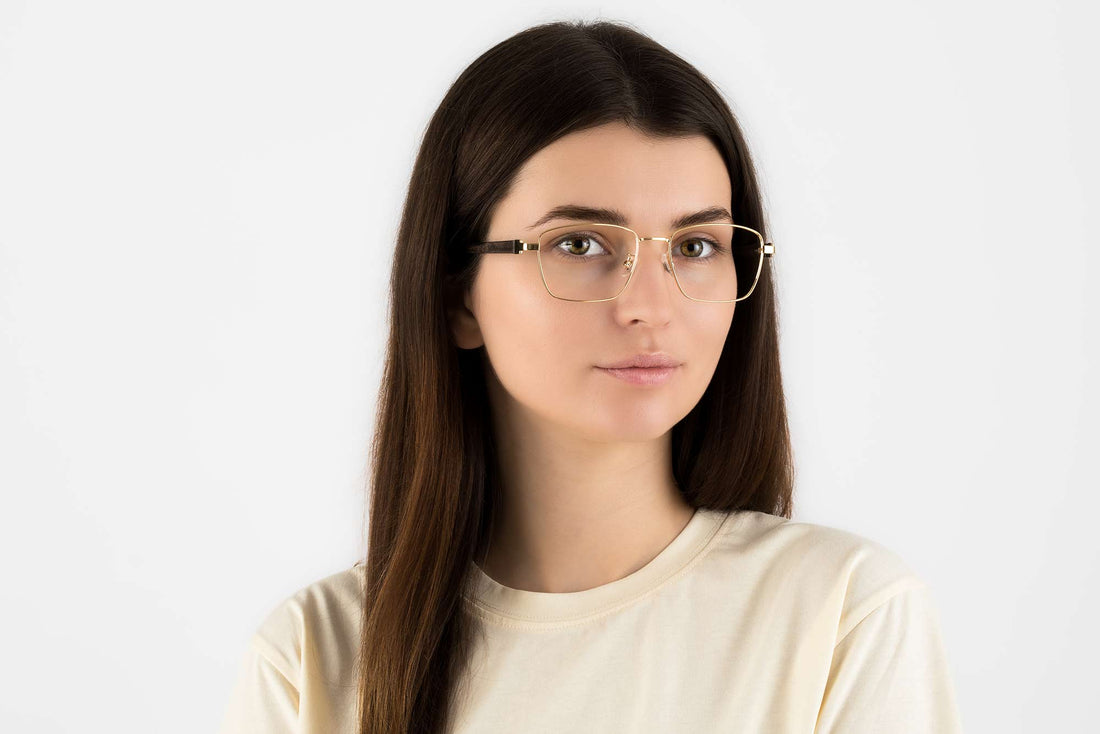 Femme portant des lunettes carrées en métal doré, or clair
