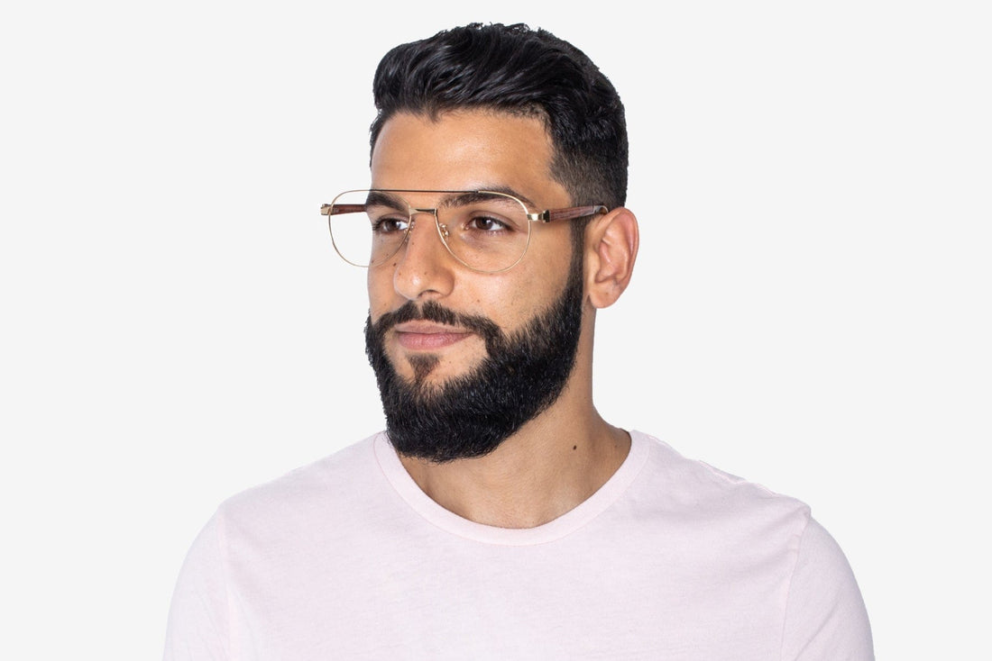 Homme portant des lunettes d'aviateur surdimensionnées et dorées.