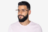 Homme portant des lunettes d'aviateur surdimensionnées et dorées.