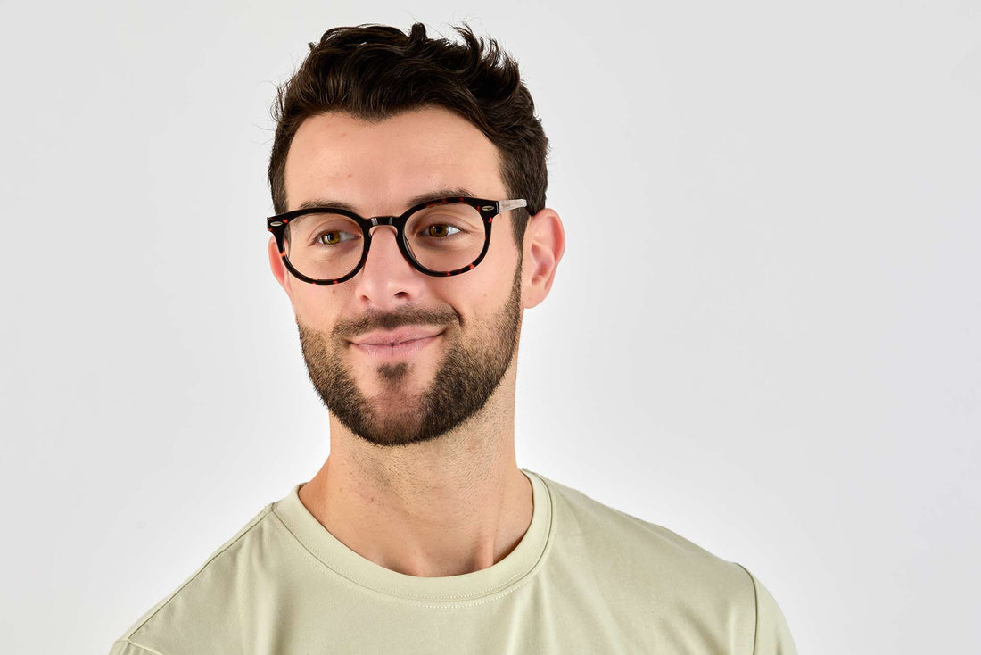 Homme portant des lunettes noires féroces, rondes et à monture noire épaisse