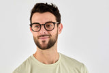 Homme portant des lunettes noires féroces, rondes et à monture noire épaisse