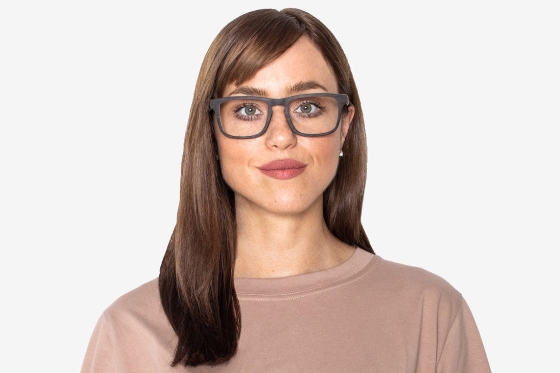 Femme portant des lunettes noires, rectangulaires, en bois de chêne noir.