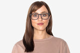 Femme portant des lunettes noires, rectangulaires, en bois de chêne noir.