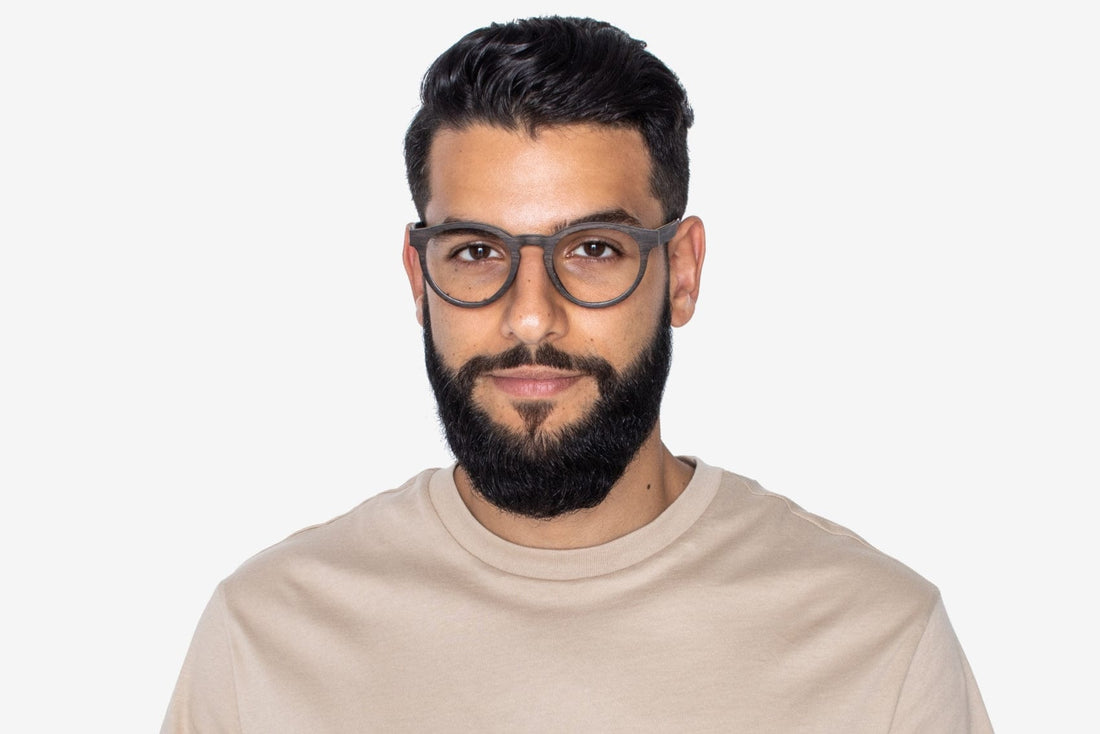 Homme portant des lunettes noires, rétro et rondes en bois de chêne