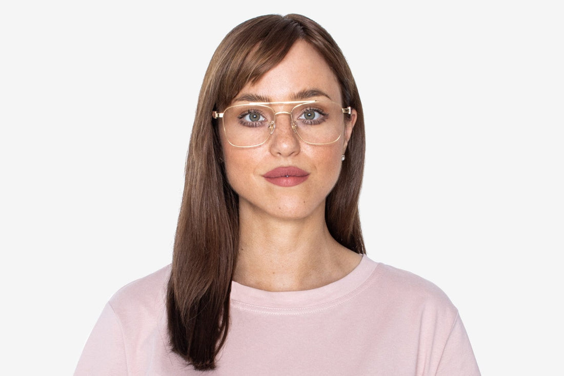 Femme portant des lunettes d'aviateur carrées rétro en or Drive