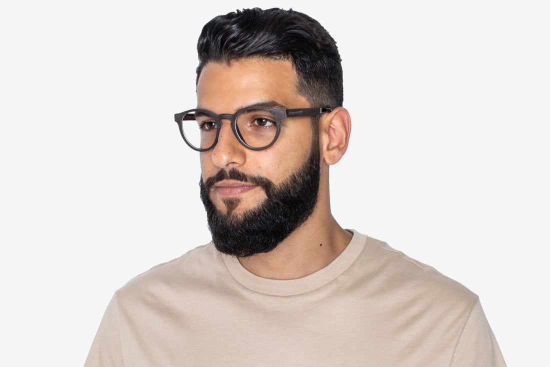 Homme portant des lunettes noires, rétro et rondes en bois de chêne