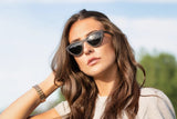 Femme portant des lunettes de soleil Selena, Small Cat Eye en noir