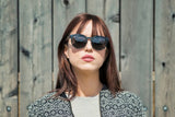 Femme portant des lunettes de soleil Luxy, noires, rondes et polarisées