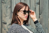 Femme portant des lunettes de soleil Luxy, noires, rondes et polarisées
