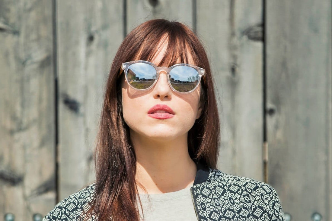 Femme portant des lunettes de soleil Groove, rondes à monture transparente et réfléchissante
